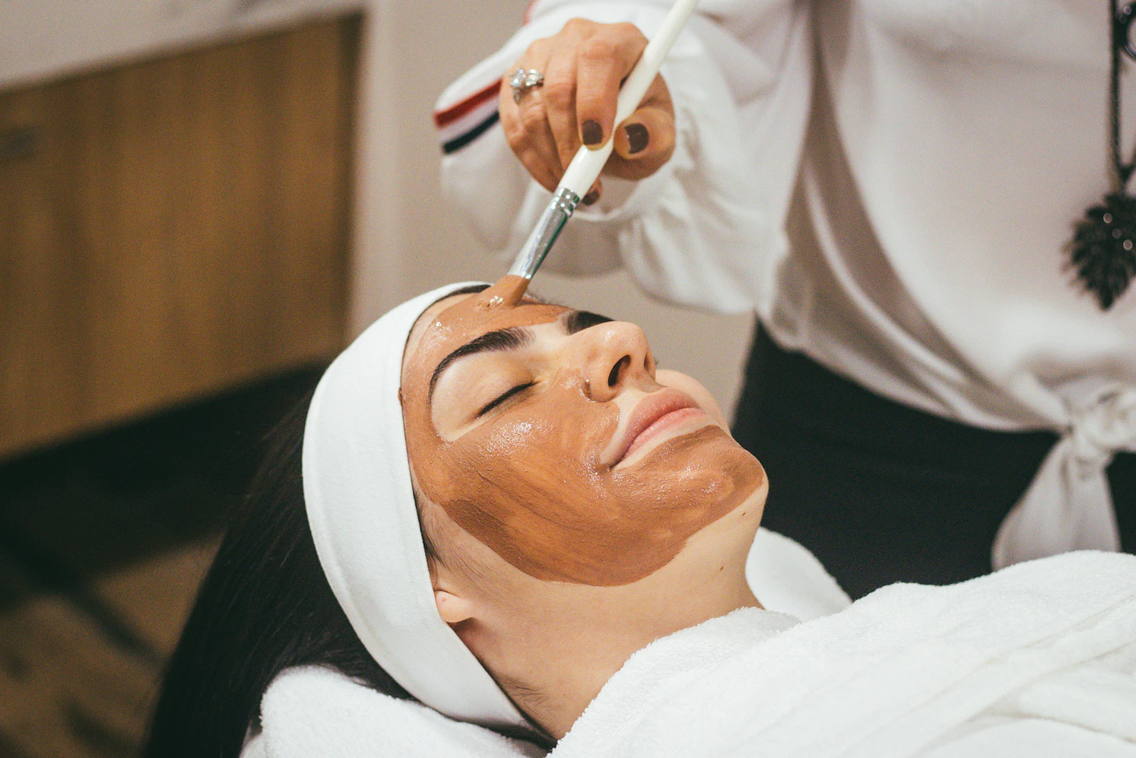 Client relaxing during a facial treatment at a spa