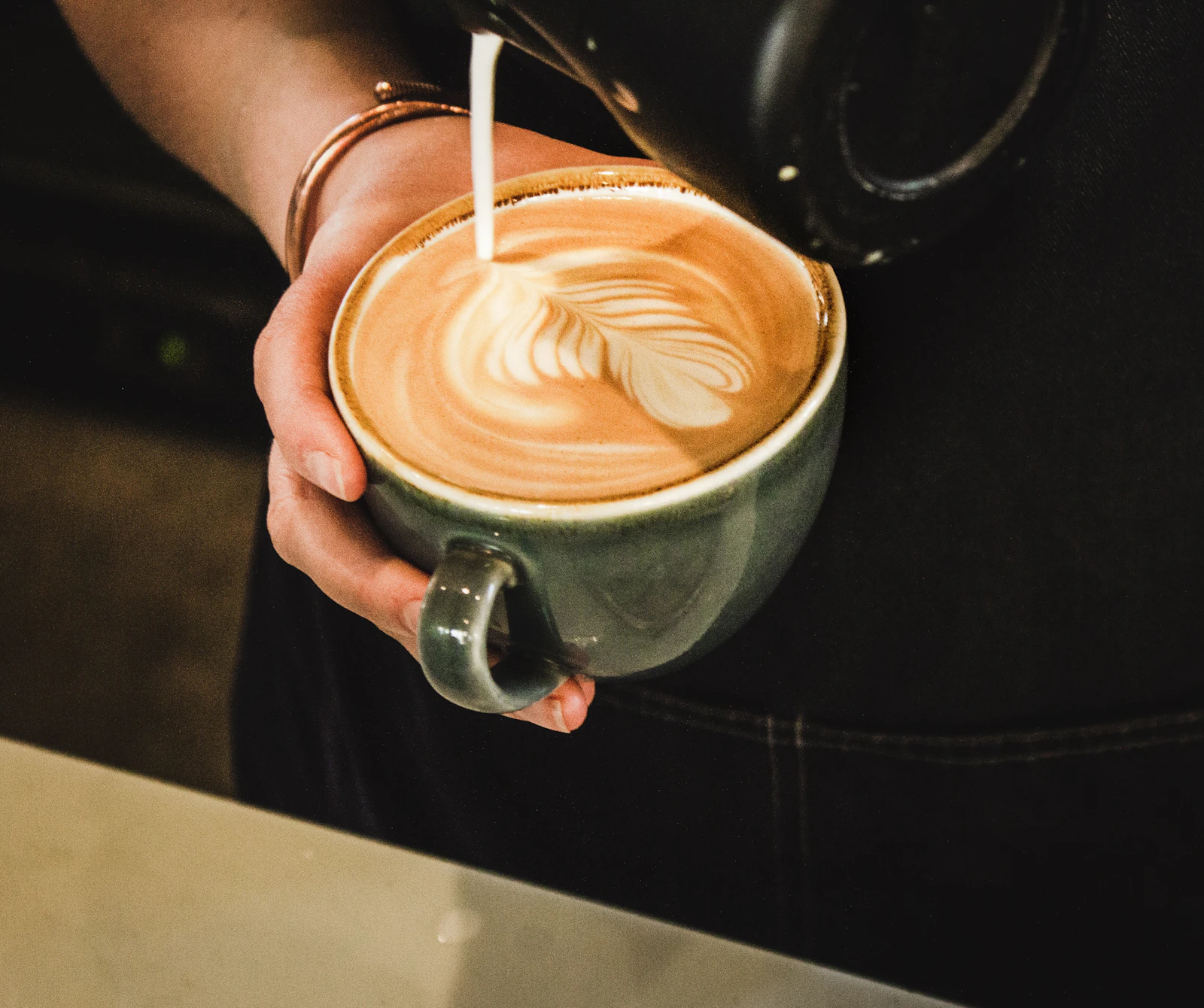 Barista serving a latte with latte art