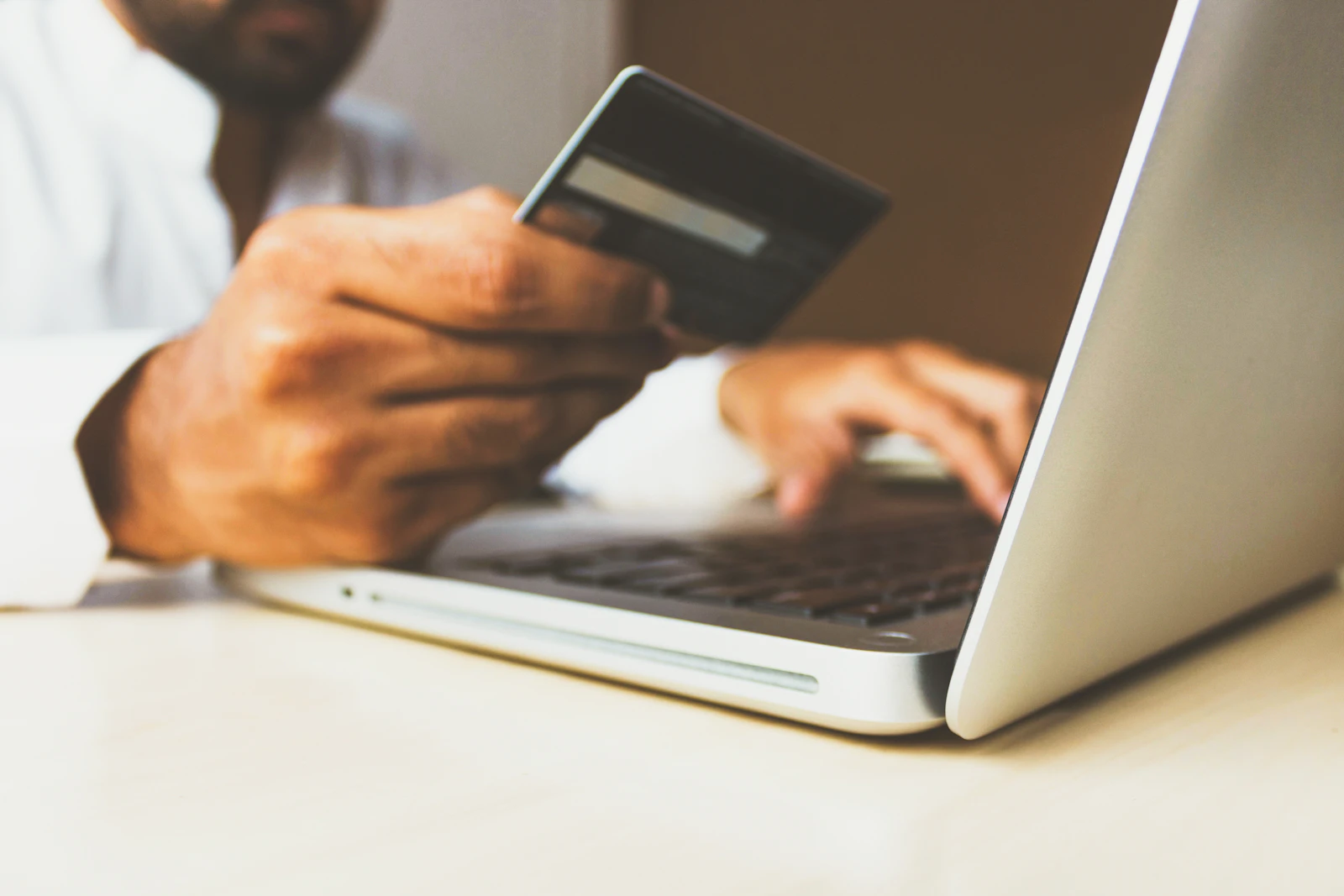 Shopper paying with a card on a laptop checkout