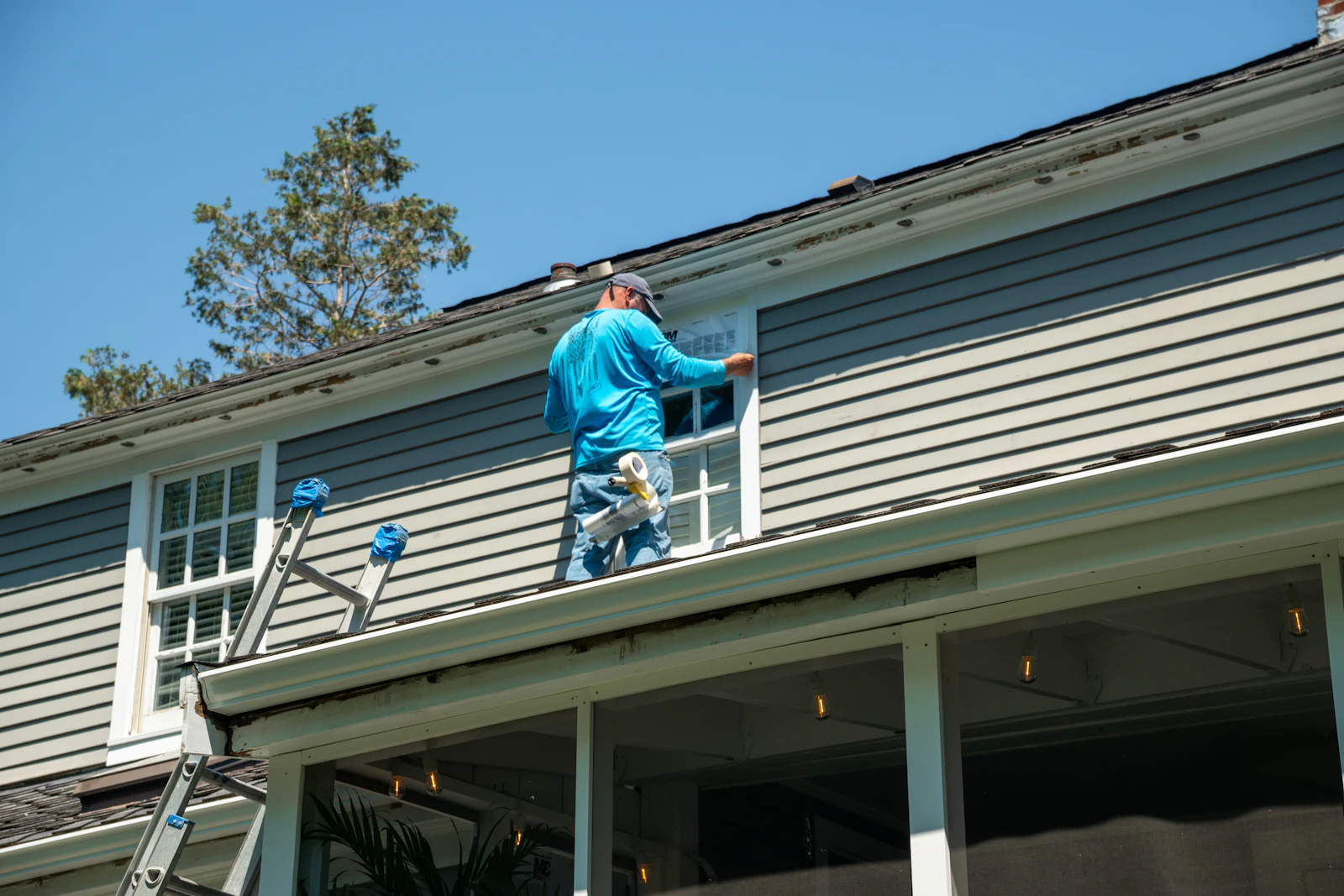 Installer fitting a window on a house exterior